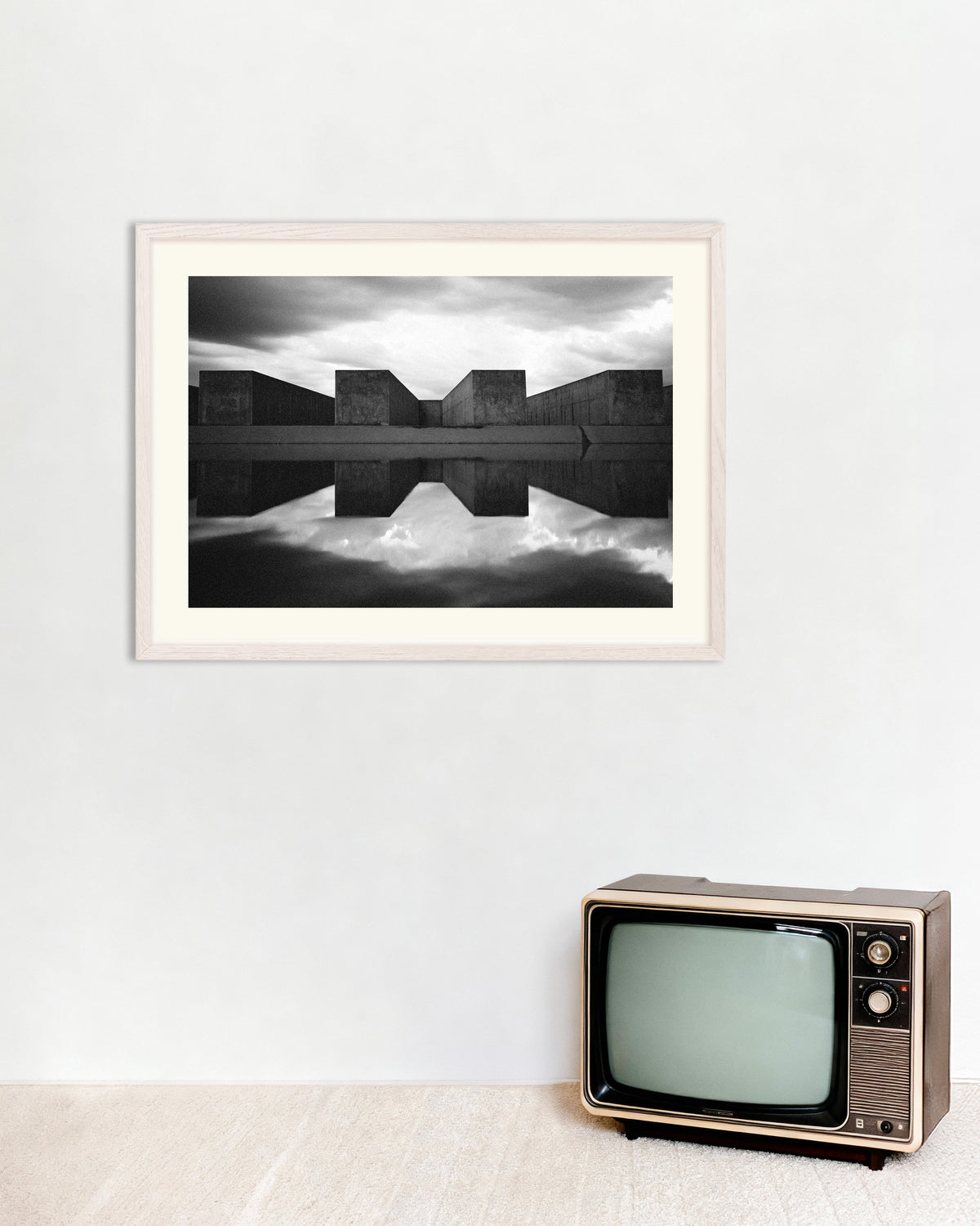 Poster ‘Betonblokken weerspiegeld in het water’, met witte houten lijst