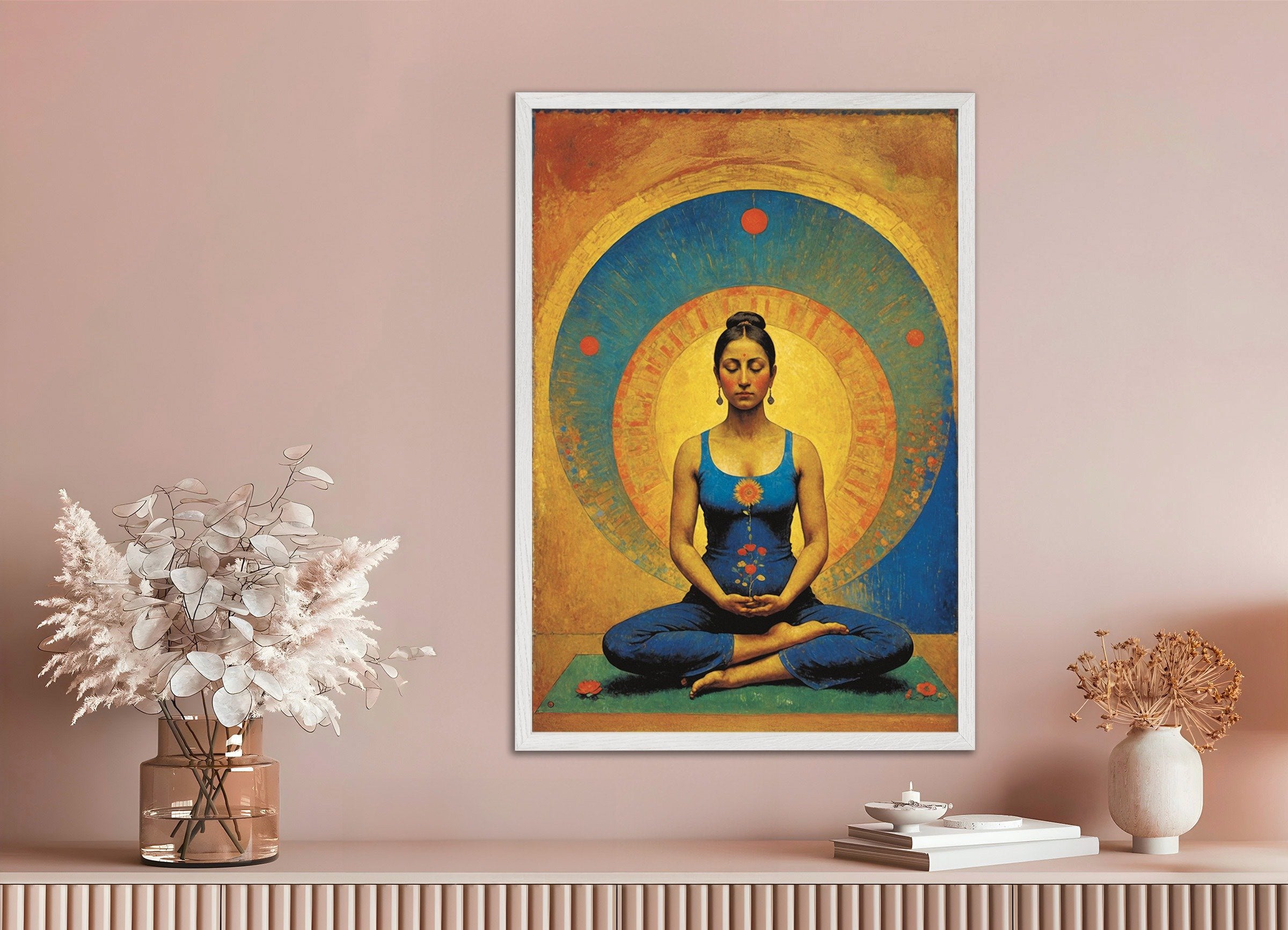 Framed artwork of a meditating figure on a pink wall with decorative items below.